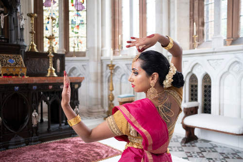 Woman dancing in pink sari in church