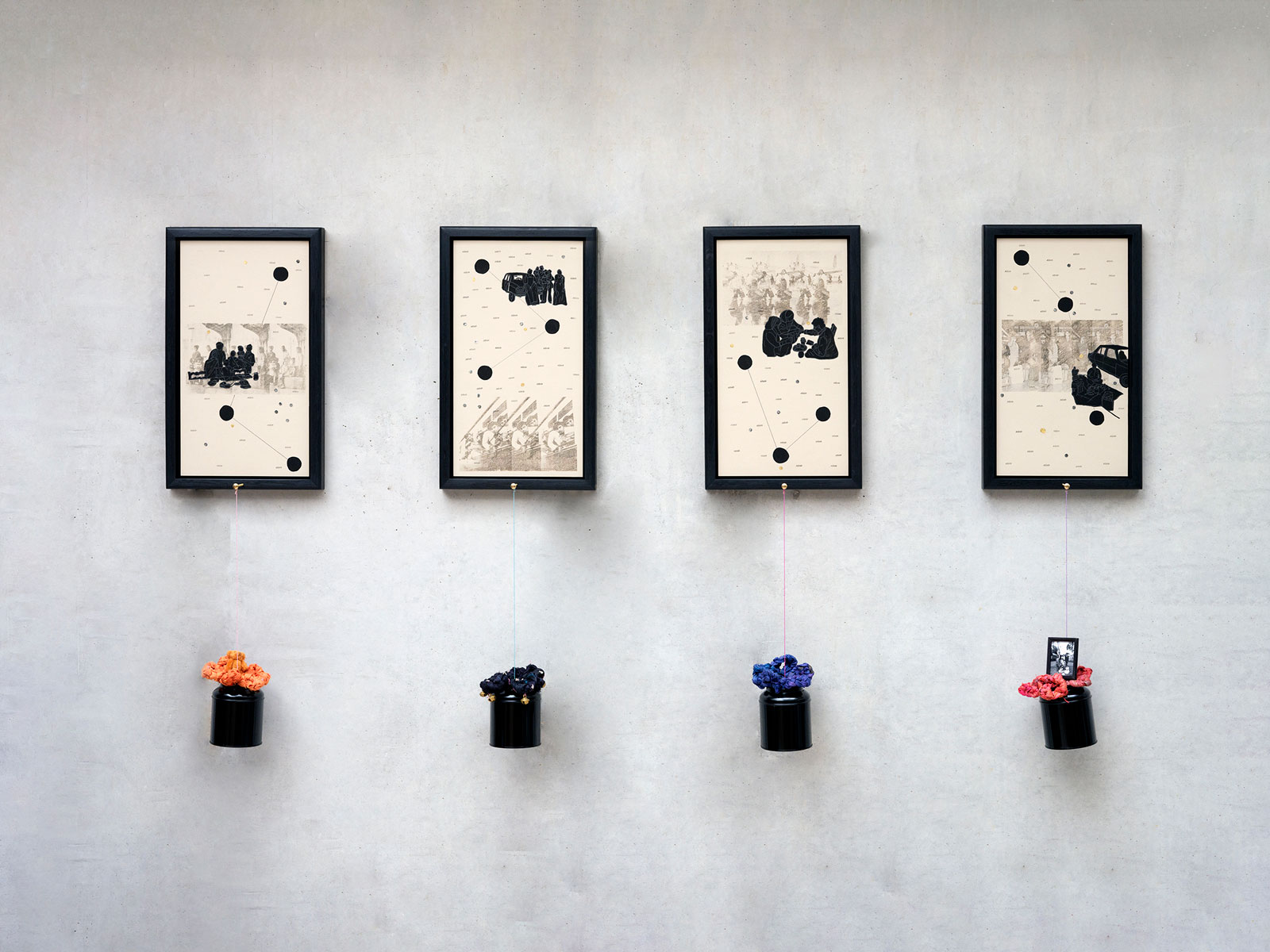 A gallery wall displays four framed artworks, each featuring a collage of translucent drawings, silhouetted figures, circular shapes, lines, and the recurring word 'Asian.' Each artwork is paired with a hanging sculpture made of colourful fabric and various miniature objects.