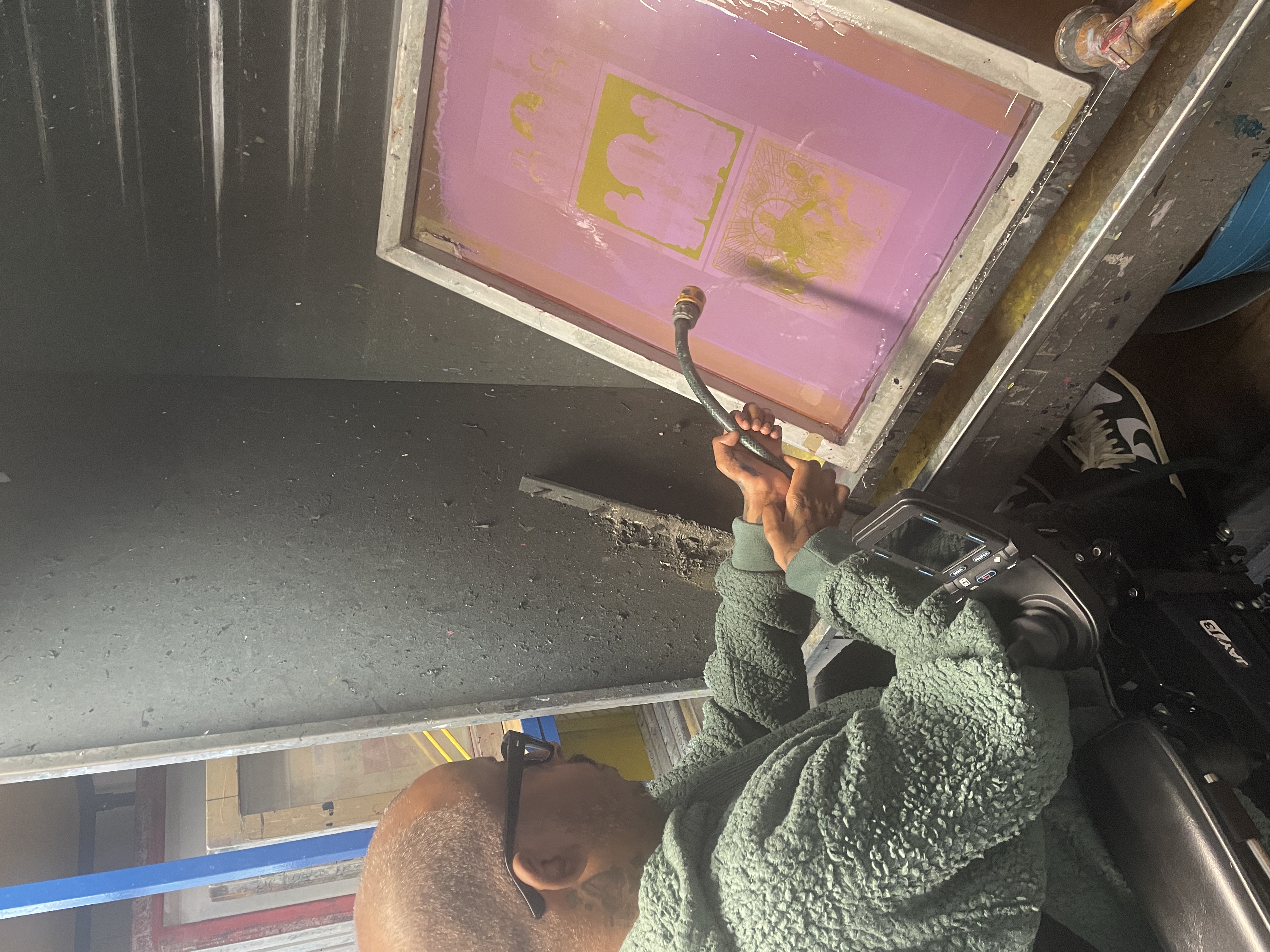 Christopher Samuel washing a screenprinting screen at Arthouse Print Studio